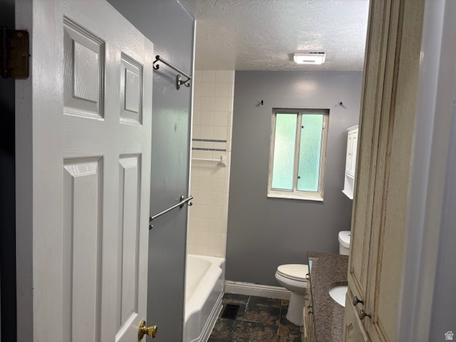 2313 150 East Bountiful, UT 84010 - Photo 24 of 39 Bathroom featuring a tub/shower combination with white subway tile surround and decorative accent strip, a window with frosted panes, vanity with a dark speckled countertop and integrated sink, and an overhead lighting fixture