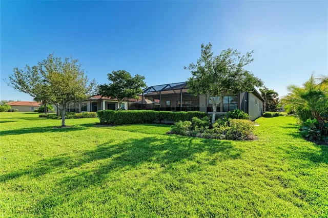 a front view of a house with a garden and palm trees