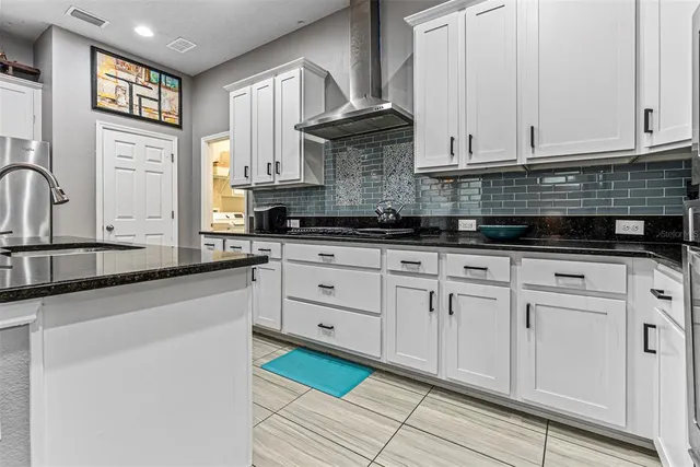 a kitchen with granite countertop white cabinets and white appliances