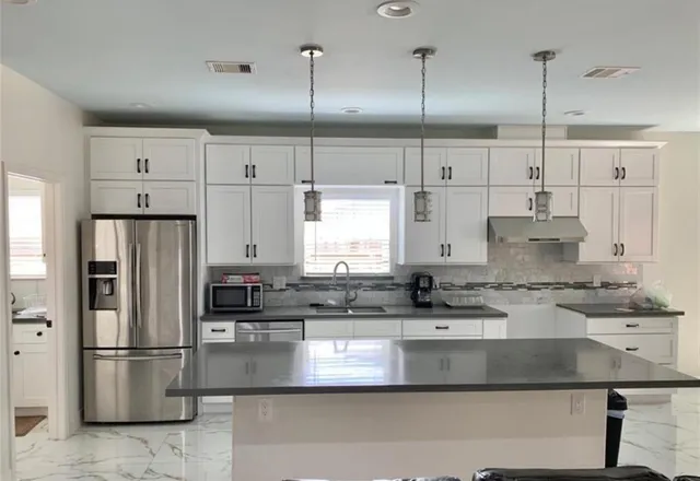 a kitchen with kitchen island a counter top space cabinets and stainless steel appliances