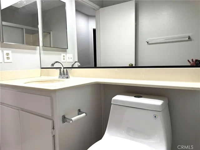 a bathroom with a sink a toilet and a mirror