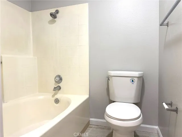 a white toilet sitting next to a bath tub