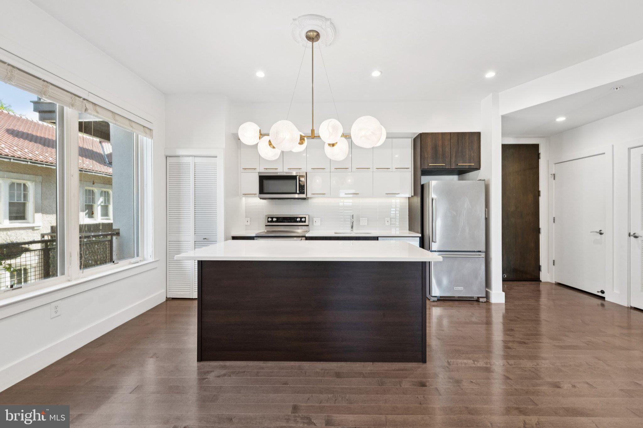 1767 Lanier Place Northwest, Unit 6 Washington, DC 20009 - Photo 23 of 49 a view of kitchen with stainless steel appliances granite countertop cabinets and a wooden floor