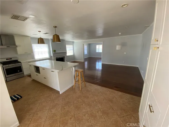 a view of a kitchen with furniture and stainless steel appliances