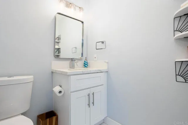 a bathroom with a sink mirror vanity and toilet
