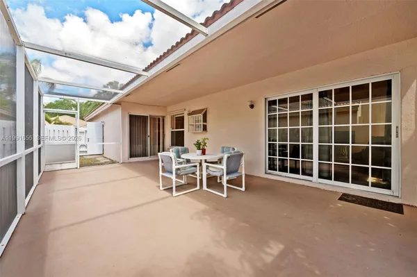 a view of a patio with table and chairs with wooden floor and fence