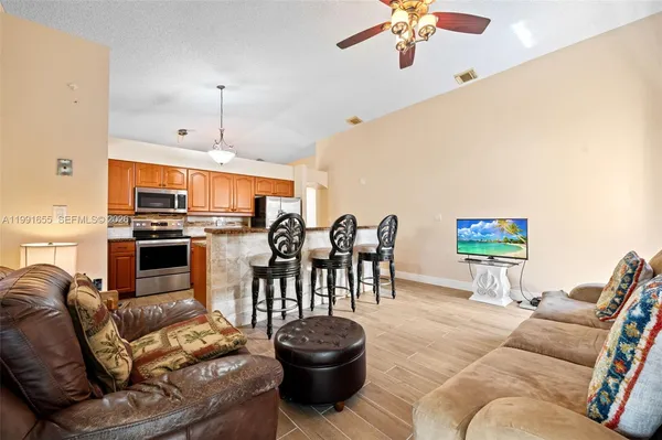 a living room with furniture kitchen view and a chandelier