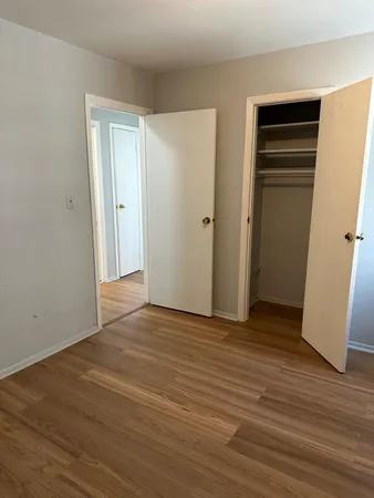 an empty room with wooden floor and closet