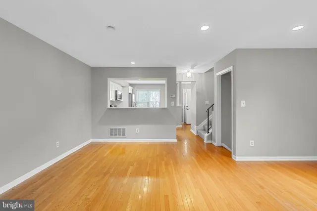 a view of empty room with wooden floor