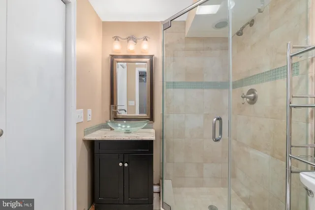 a bathroom with a granite countertop shower a mirror and a sink