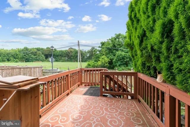 a view of roof deck with wooden floor and fence