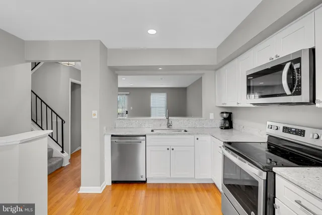 a kitchen with stainless steel appliances a stove microwave and sink