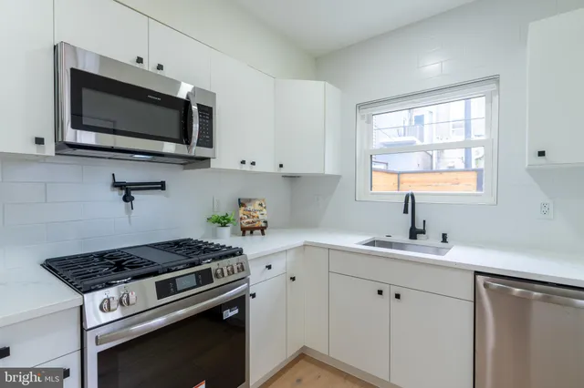 a kitchen with a sink stove and microwave