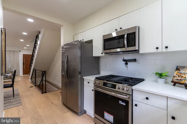 a kitchen with stainless steel appliances a stove microwave and sink