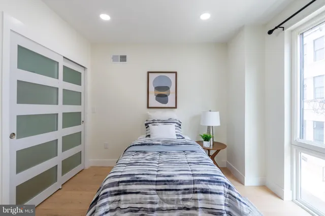 a view of a bedroom with wooden floor and a window