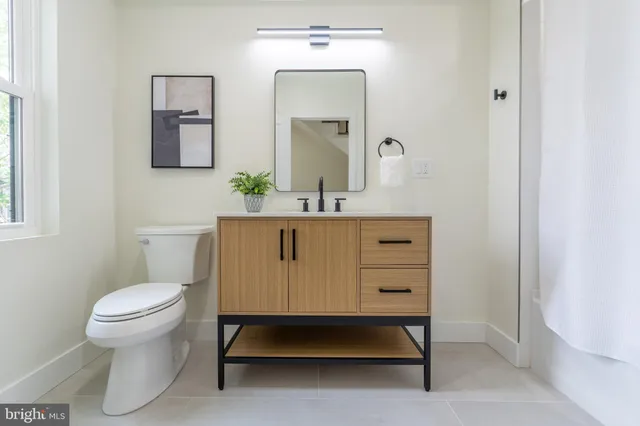 a bathroom with a toilet a sink and mirror