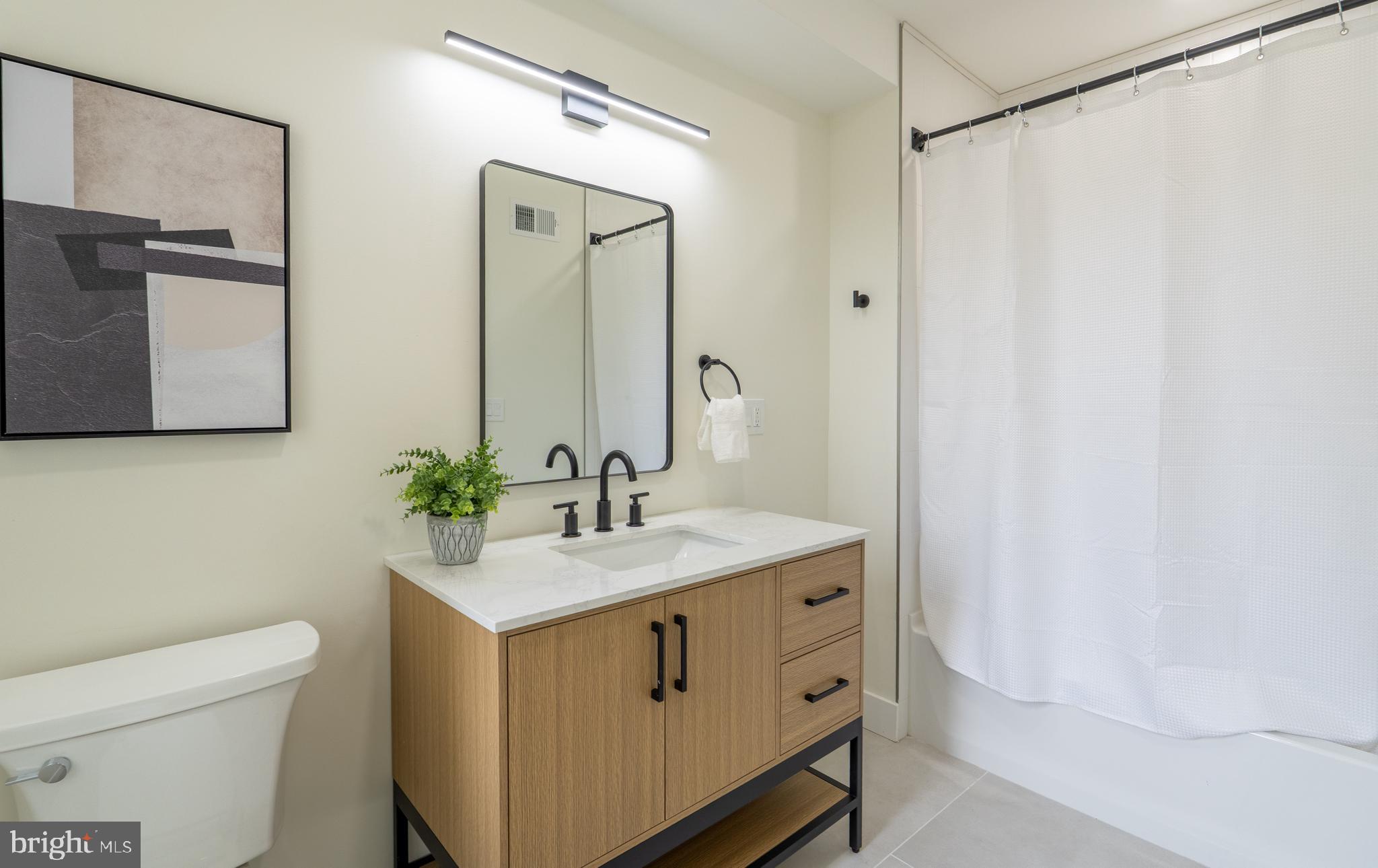 622 McClellan Street Philadelphia, PA 19148 - Photo 25 of 52 a bathroom with a sink a toilet and mirror