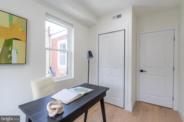 a view of a workspace with furniture and a window