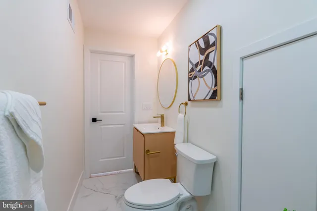 a white toilet sitting next to a bathroom sink and vanity