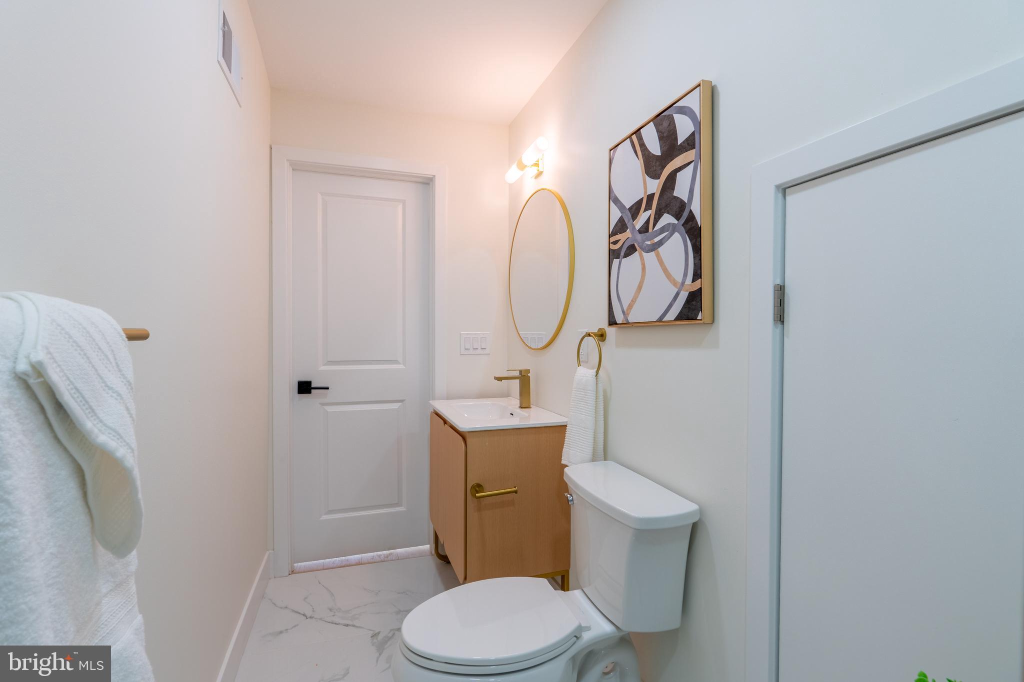 622 McClellan Street Philadelphia, PA 19148 - Photo 38 of 52 a white toilet sitting next to a bathroom sink and vanity