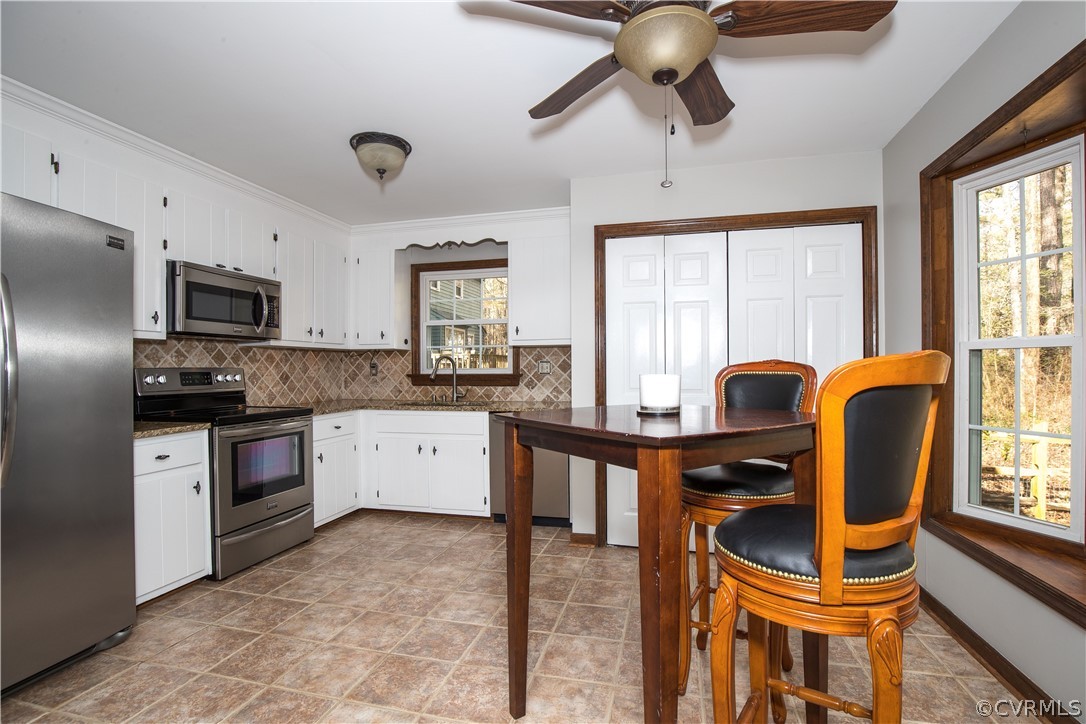 3003 Sagegrove Road Midlothian, VA 23112 - Photo 7 of 22 a kitchen with stainless steel appliances granite countertop a stove a sink dishwasher a dining table and chairs with wooden floors