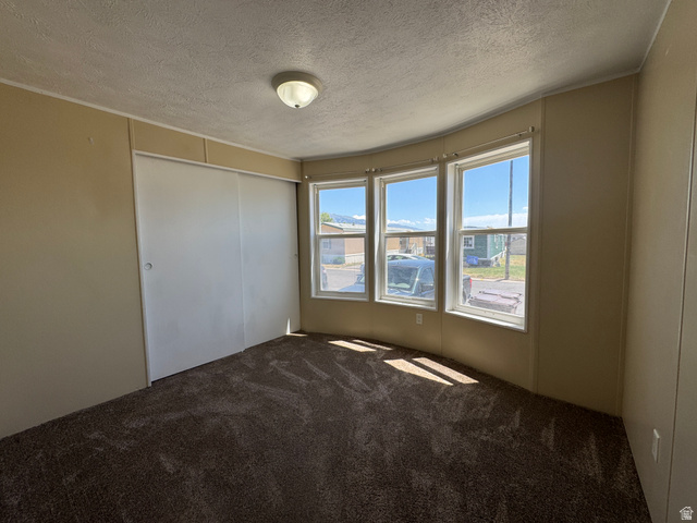 2491 Highway 89, Unit 315 Pleasant View, UT 84404 - Photo 34 of 34 Room featuring three bay windows, wall-to-wall carpeting, light neutral wall paneling, and a flush mount ceiling light fixture