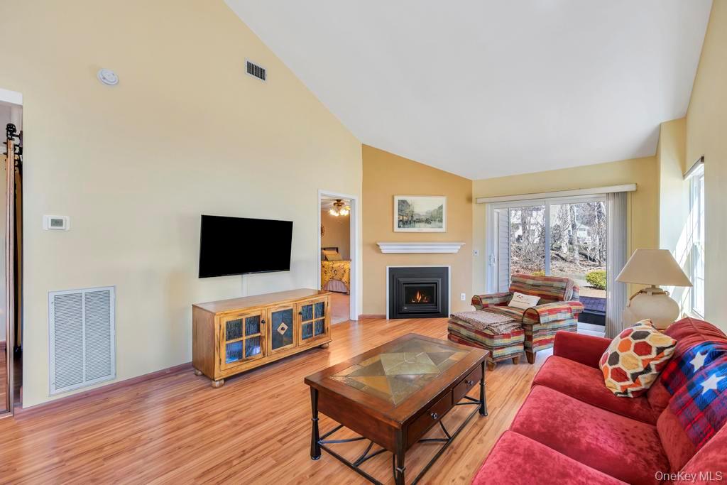 13 Mallard Path Coram, NY 11727 - Photo 17 of 39 a living room with furniture a flat screen tv and a fireplace