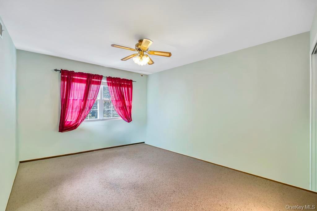 13 Mallard Path Coram, NY 11727 - Photo 18 of 39 an empty room with windows and fan