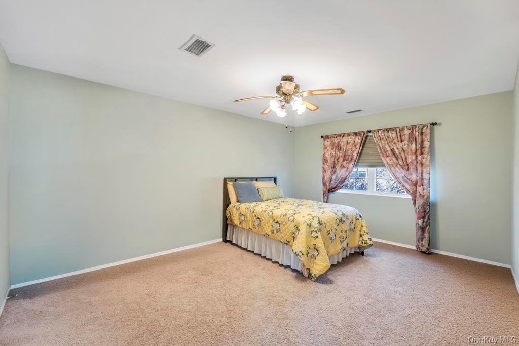 13 Mallard Path Coram, NY 11727 - Photo 22 of 39 a bedroom with a bed and a painting on the wall