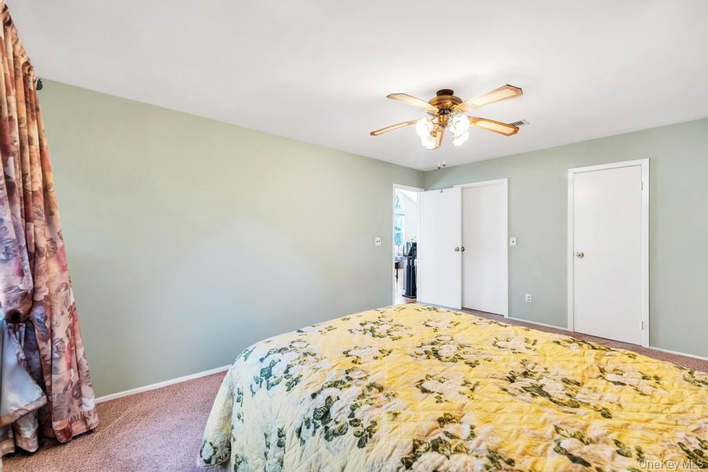 13 Mallard Path Coram, NY 11727 - Photo 23 of 39 a bedroom with a bed and a chandelier