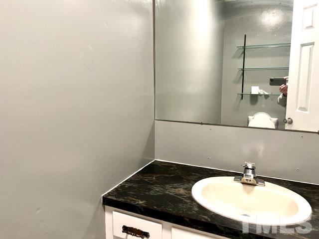 115 Kerr Lake Club Road Henderson, NC 27537 - Photo 20 of 20 a bathroom with a granite countertop sink and a mirror