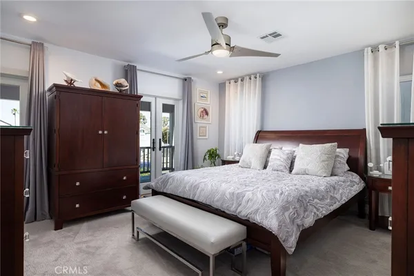 a bedroom with a bed and a flat tv screen on dresser
