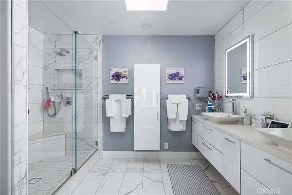 a spacious bathroom with a double vanity sink a mirror and a shower