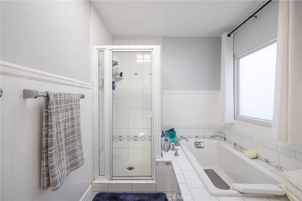 a bathroom with a tub a sink and a window