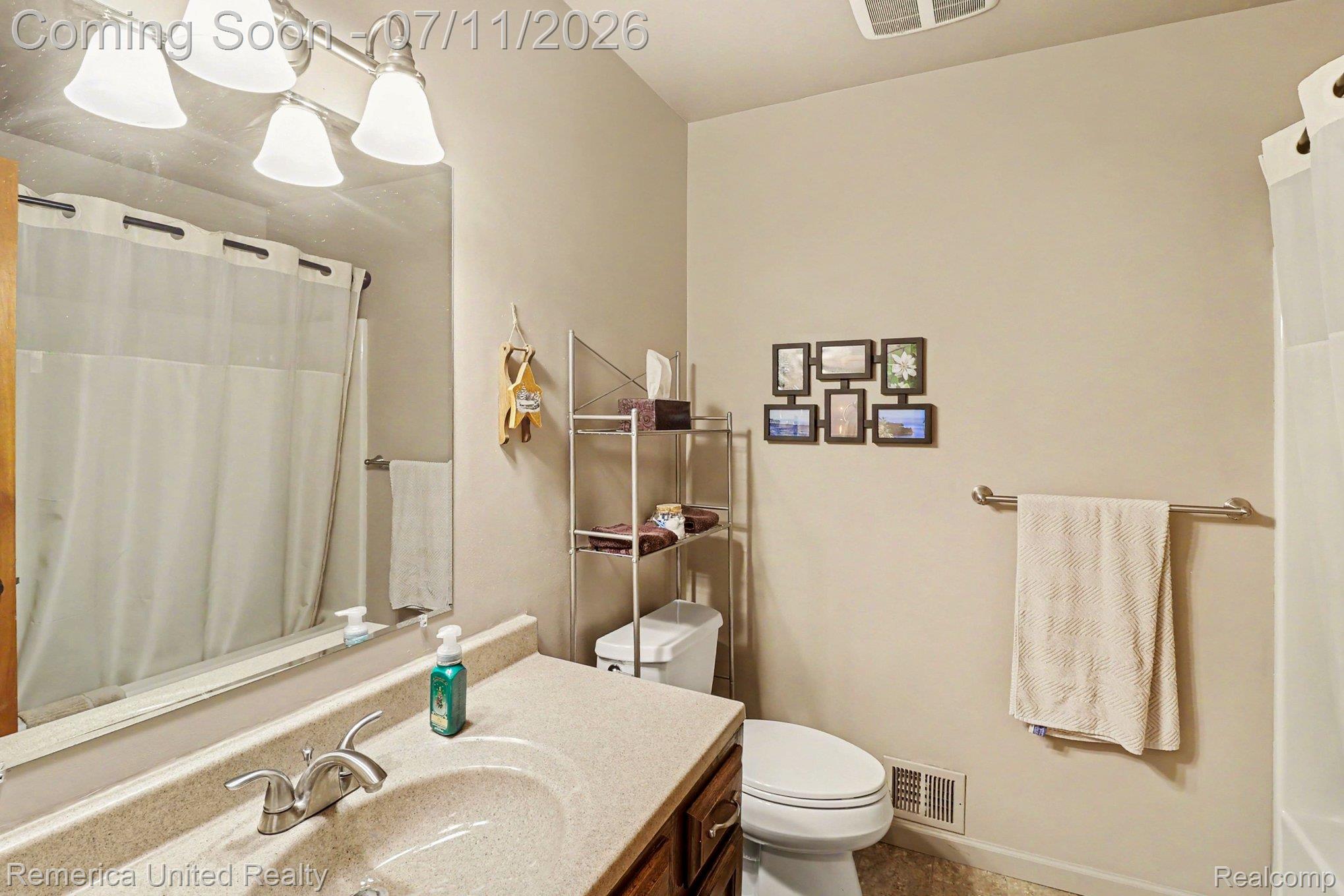 136 Endicott Howell, MI 48843 - Photo 21 of 28 Bathroom featuring a vanity with a light-colored countertop, an integrated sink, and a chrome faucet