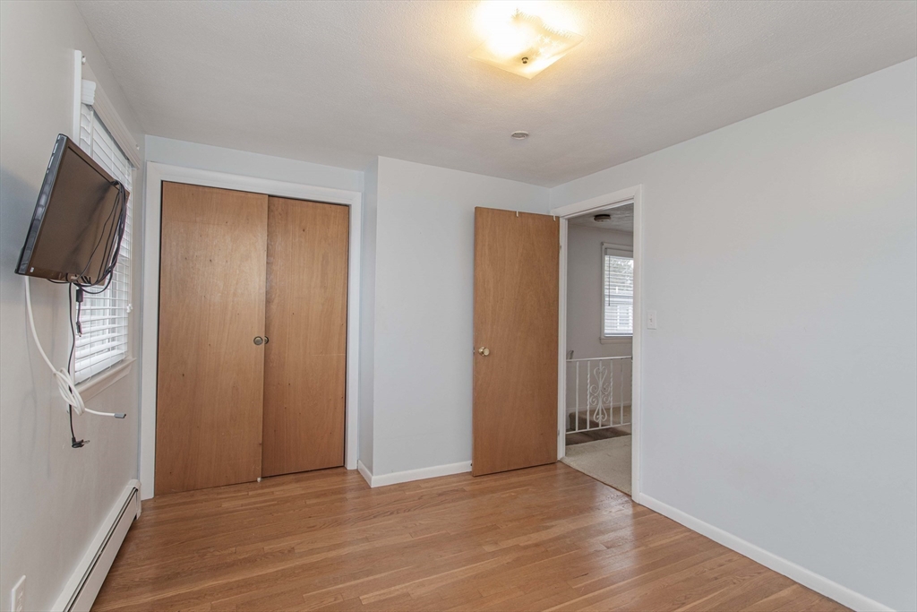 71 Vallaro Road Boston, MA 02136 - Photo 21 of 37 a view of an empty room with wooden floor and a window