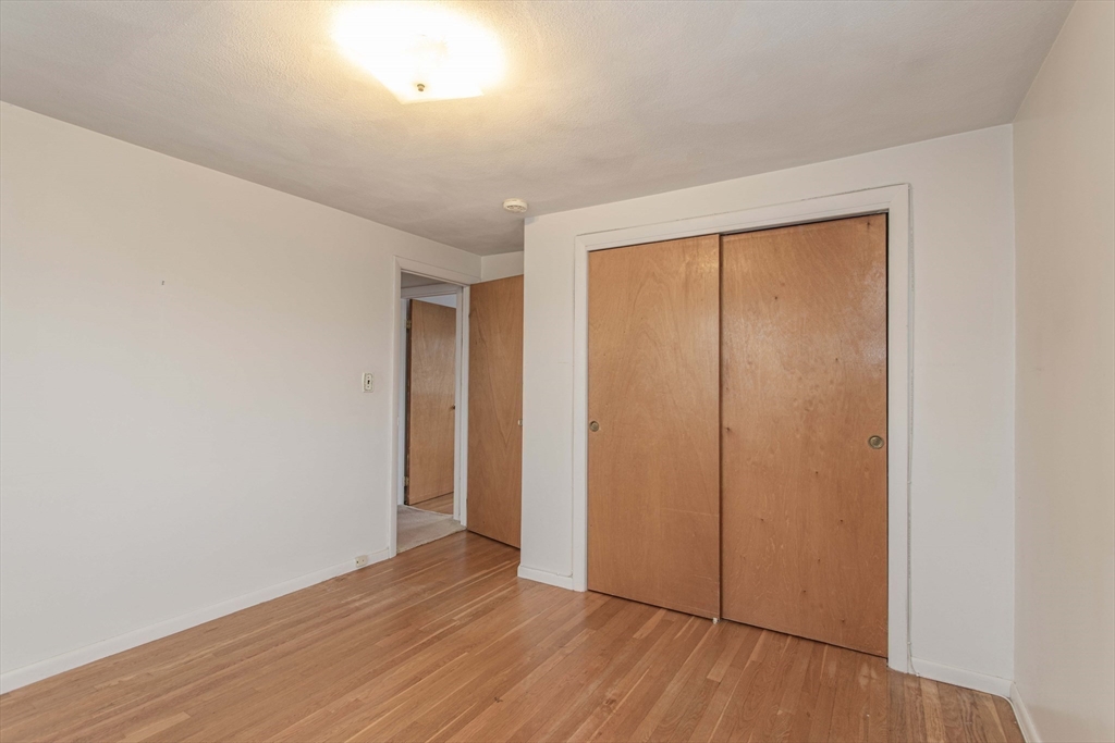 71 Vallaro Road Boston, MA 02136 - Photo 24 of 37 an empty room with wooden floor and sliding door