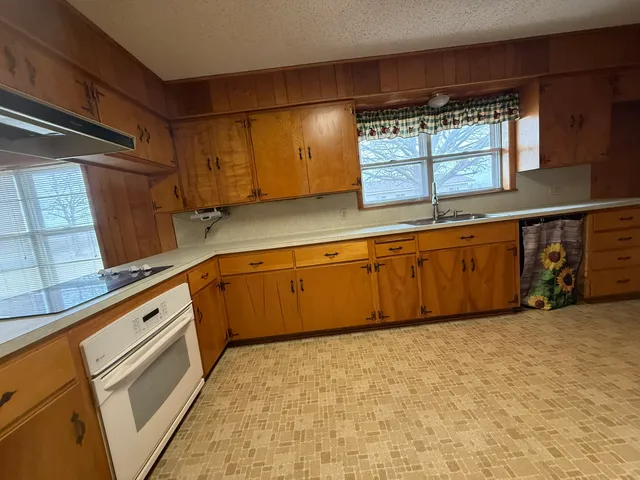a large kitchen with granite countertop a sink and a stove