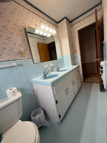 a bathroom with a toilet sink and mirror