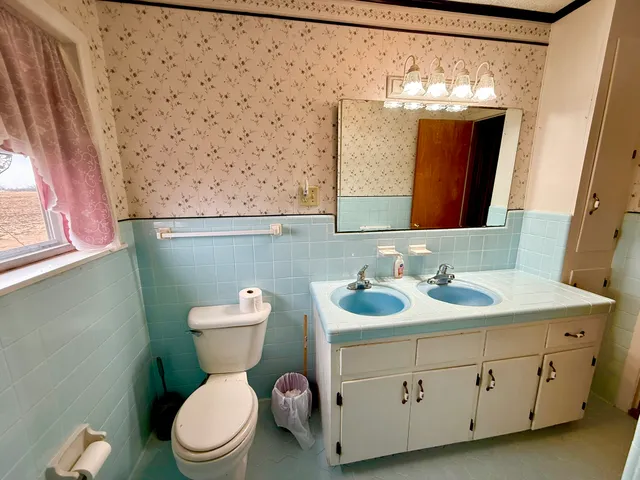 a bathroom with a toilet sink and mirror