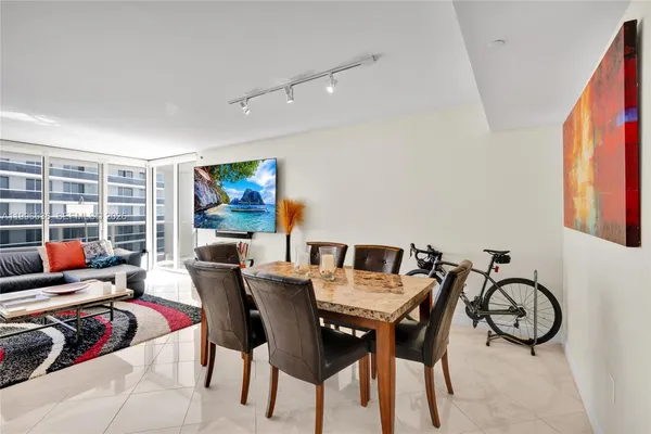 a view of a dining room with furniture a rug and wooden floor