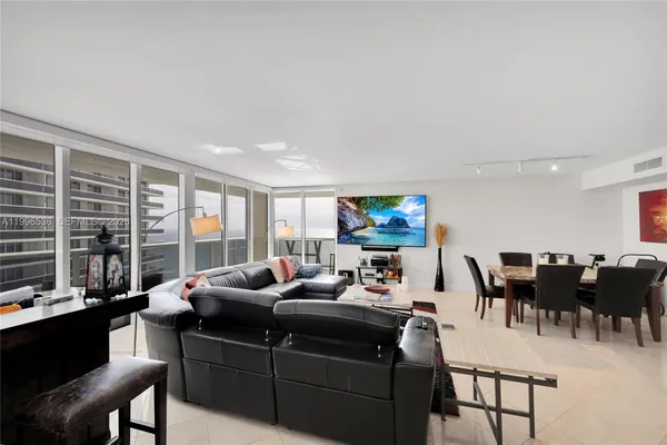 a living room with furniture a flat screen tv and a large window
