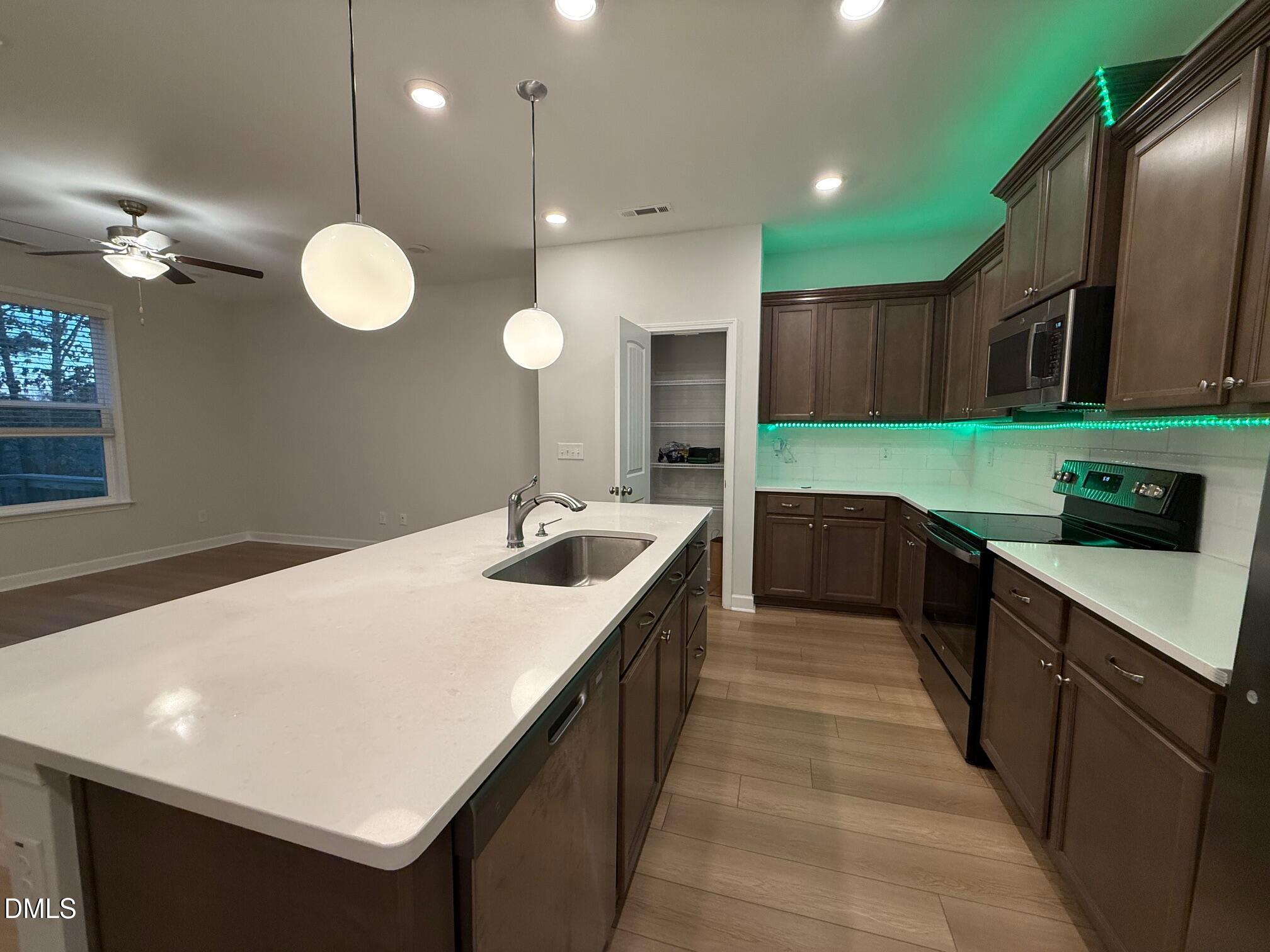 230 George Pine Way Knightdale, NC 27545 - Photo 28 of 31 a kitchen with kitchen island a sink stainless steel appliances and a counter top space