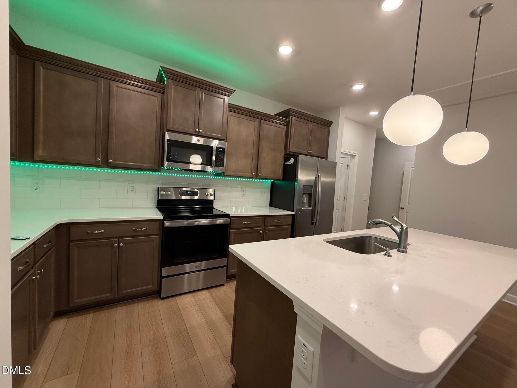 230 George Pine Way Knightdale, NC 27545 - Photo 29 of 31 a kitchen with kitchen island granite countertop a sink stainless steel appliances and cabinets