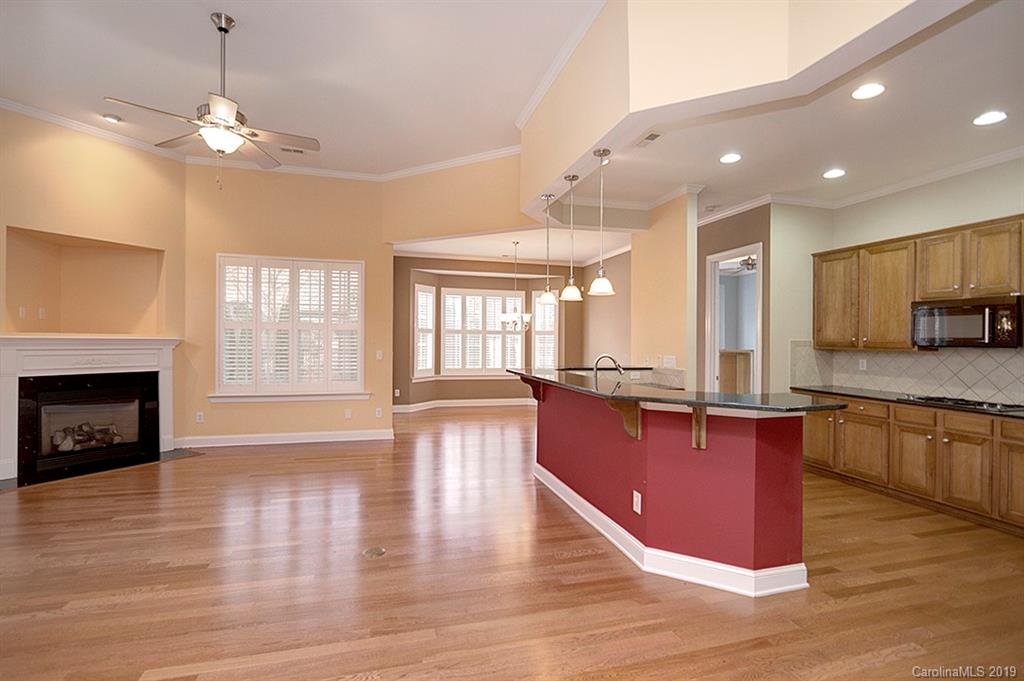 907 Treasure Court Fort Mill, SC 29708 - Photo 9 of 31 a large kitchen with granite countertop a stove top oven a sink a counter space and living room view