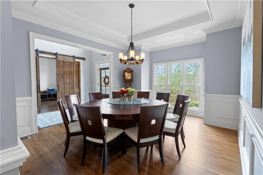 1625 Hamiota Ridge Alpharetta, GA 30004 - Photo 16 of 86 a dining room with wooden floor a chandelier a wooden table and chairs