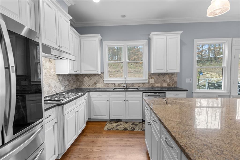 1625 Hamiota Ridge Alpharetta, GA 30004 - Photo 21 of 86 a kitchen with stainless steel appliances granite countertop a stove sink and cabinets