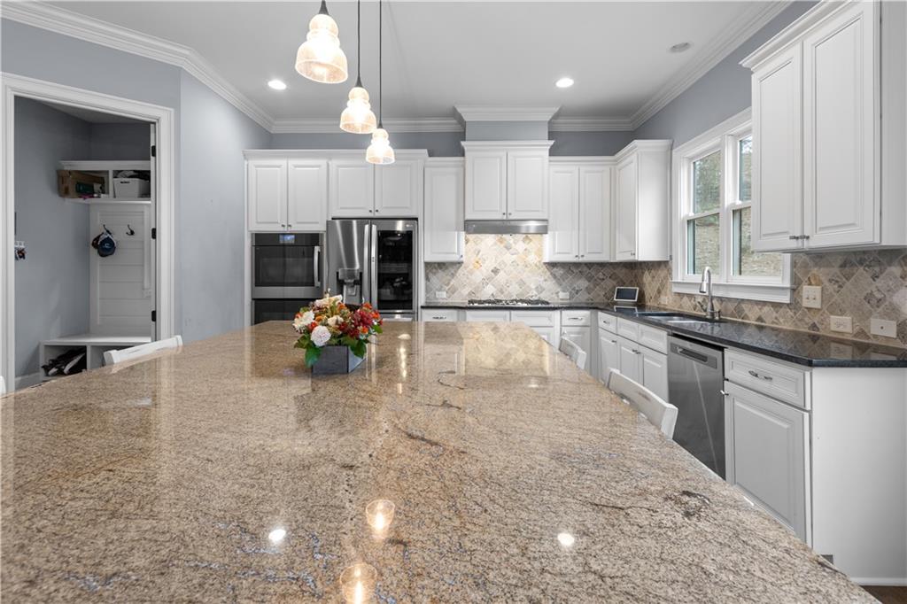 1625 Hamiota Ridge Alpharetta, GA 30004 - Photo 22 of 86 a kitchen with stainless steel appliances granite countertop a sink stove and cabinets