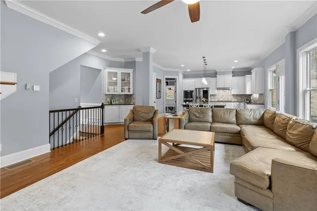 a spacious bedroom with a bed a couch and a ceiling fan