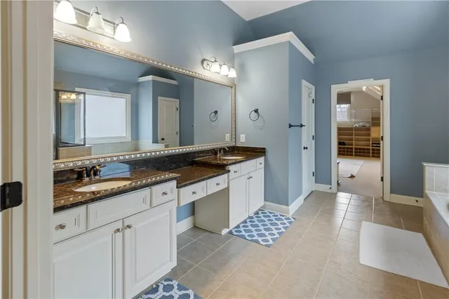 a view of a house with brick walls plants and large tree